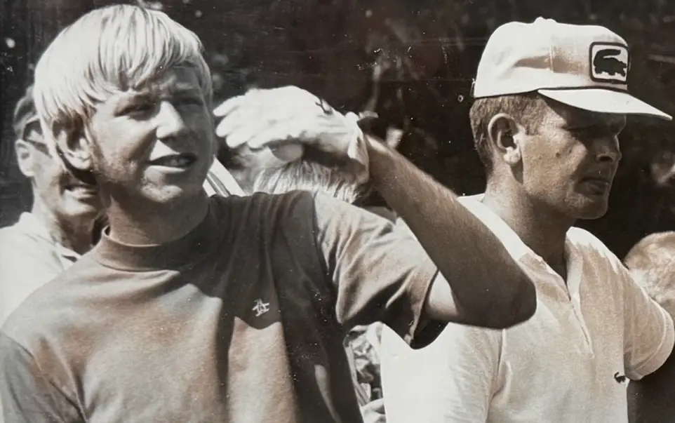 Vintage black and white photograph showing a young golfer standing among spectators during an outdoor golf event