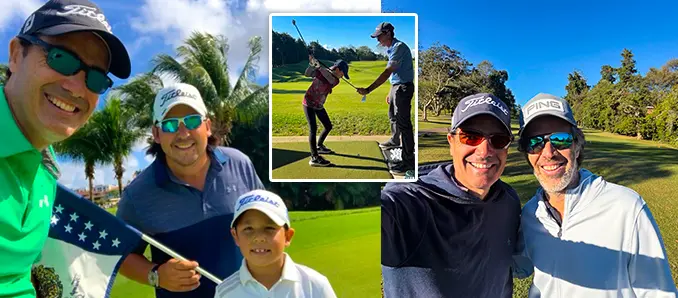 Professional golf instructor coaching adult and junior students during an on-course golf lesson, demonstrating proper swing technique at a sunny driving range
